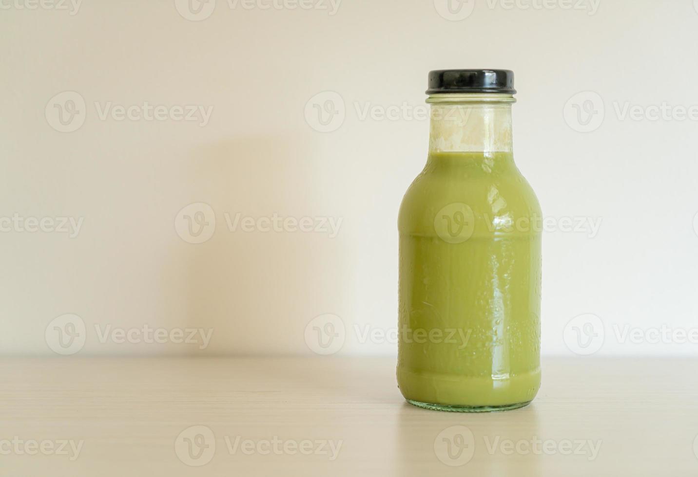 Latte de té verde matcha en botella de vidrio sobre la mesa foto