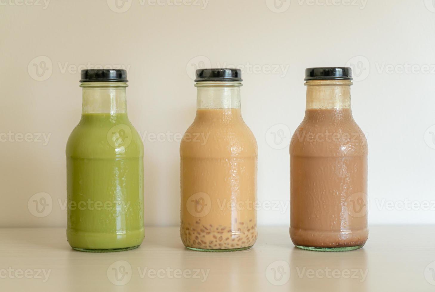 Matcha green tea latte, chocolate and milk tea with pudding jelly in glass bottle on the table photo