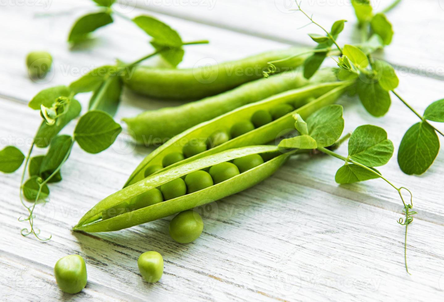 guisantes verdes sobre un fondo de madera blanca. Fondo de comida sana. foto