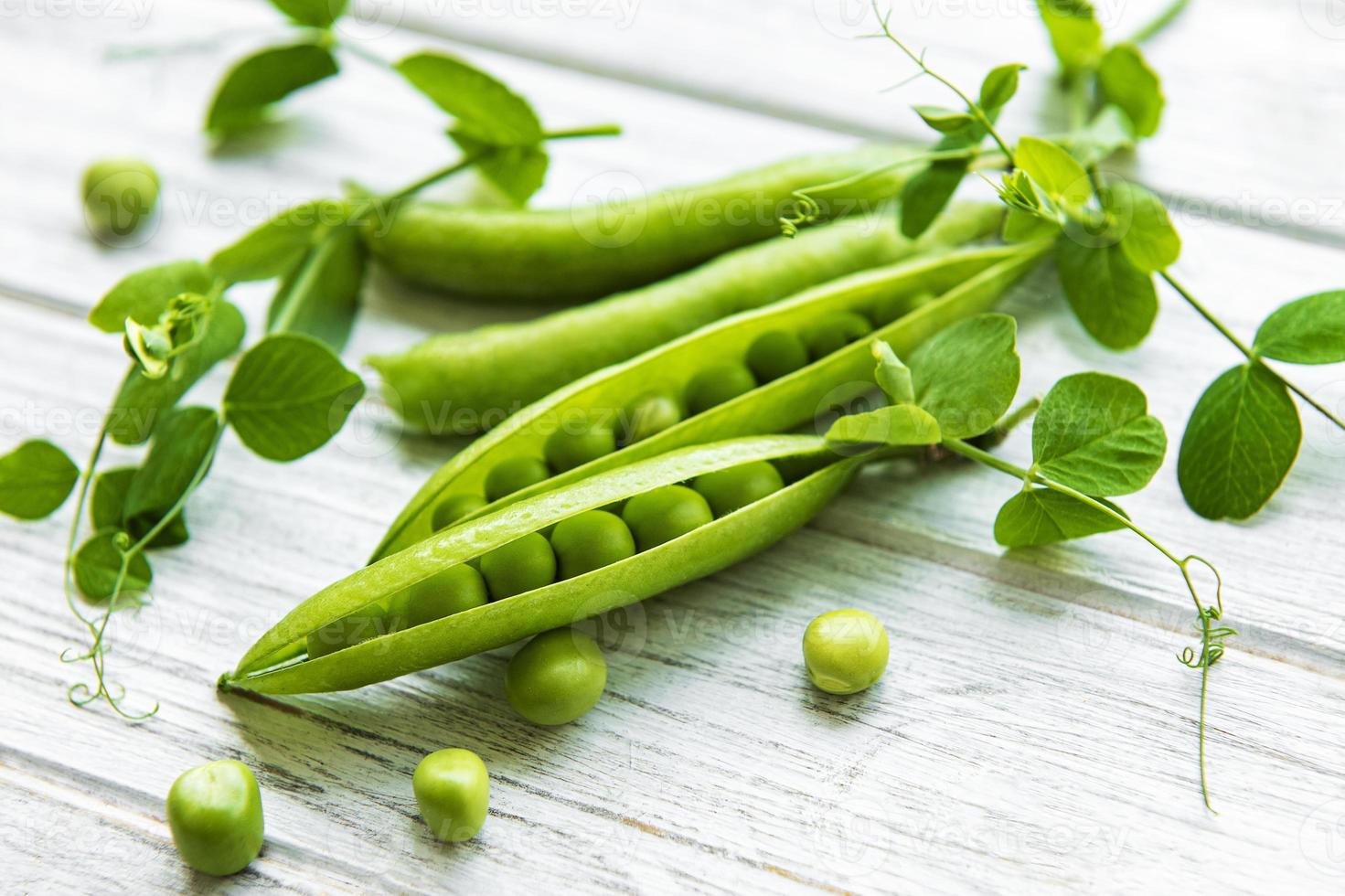 guisantes verdes sobre un fondo de madera blanca. Fondo de comida sana. foto