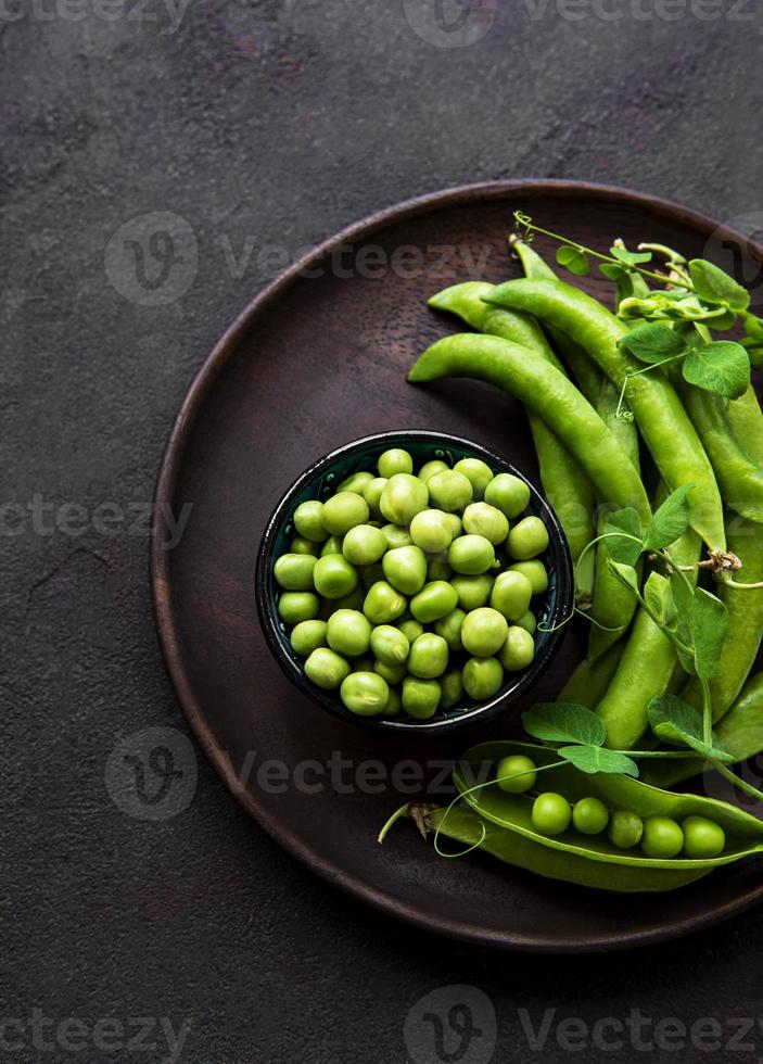 Green peas in  bowl with fresh pods photo