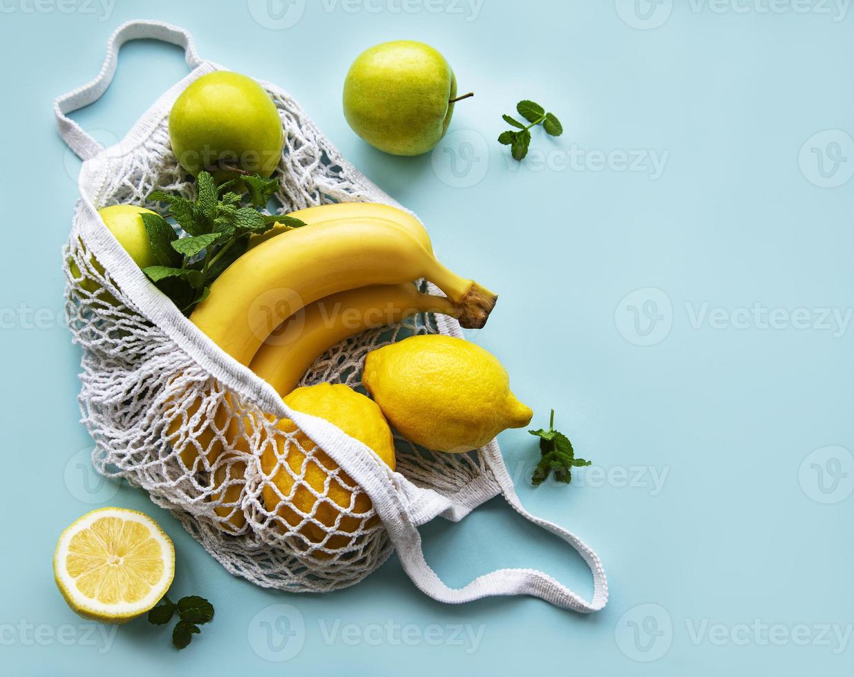 jugosos cítricos maduros y plátanos en una bolsa de compras ecológica foto
