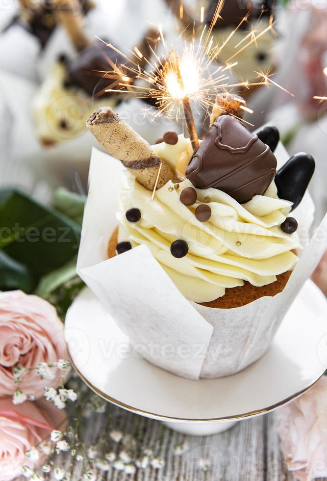 Cupcakes de chocolate con estrellitas sobre fondo blanco de madera foto