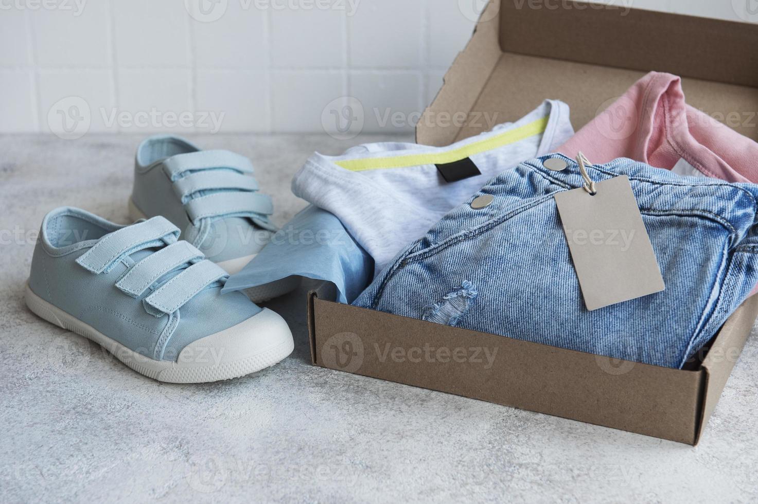 Clothes fir kids in an open cardboard box photo