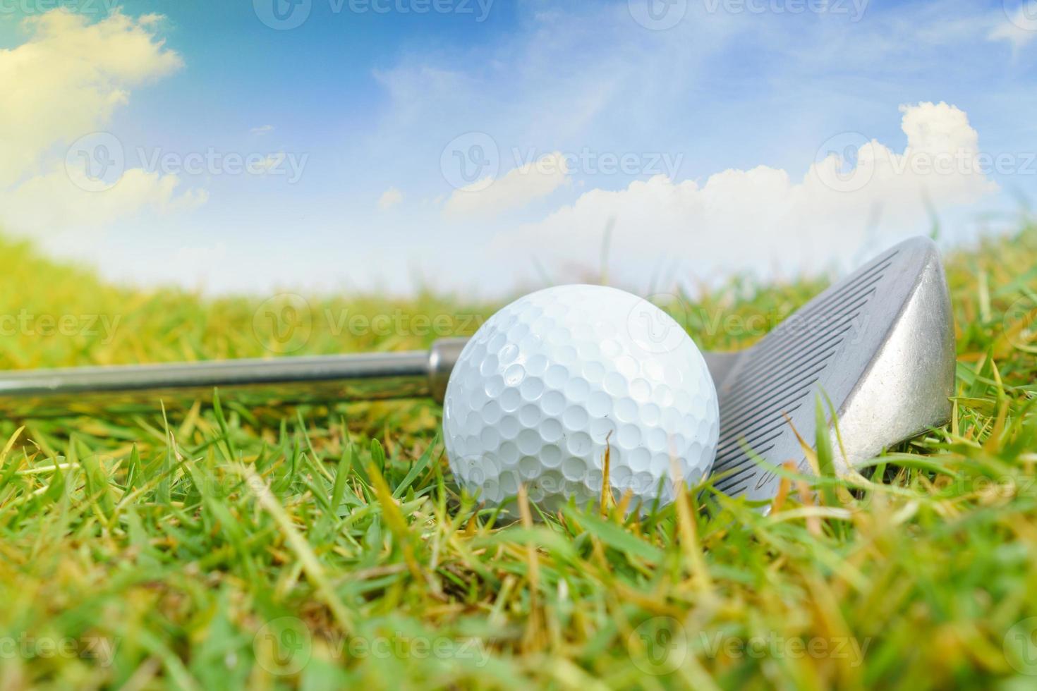 Golf clubs and golf ball on green grass background photo