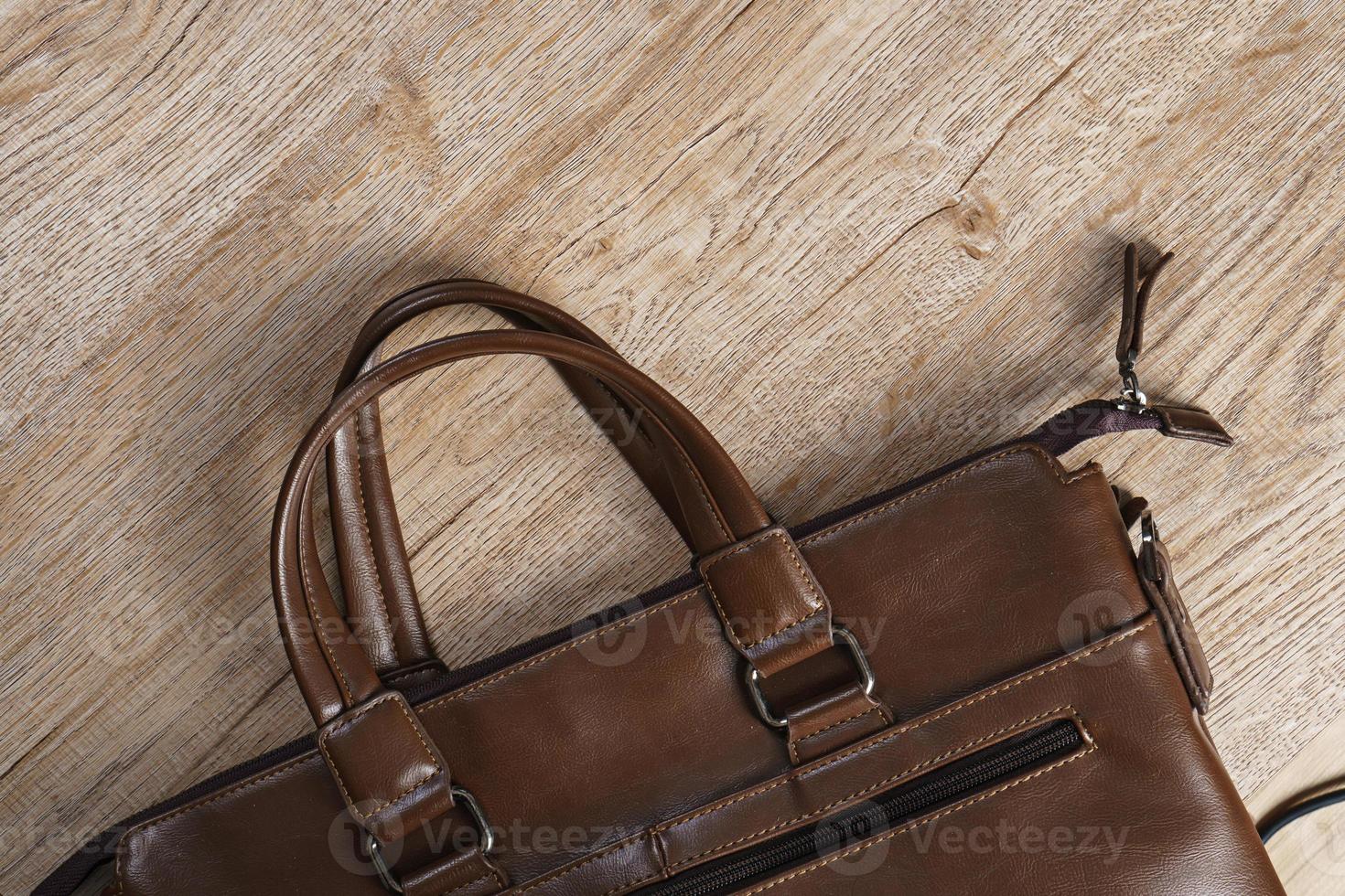 Leather bag on wooden board background photo