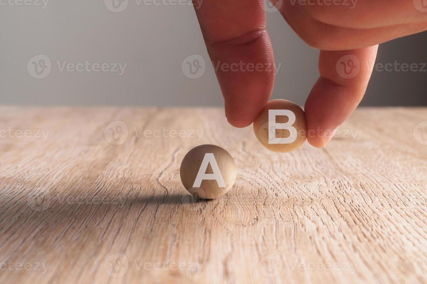 Hand putting on A-B word written in wooden ball photo