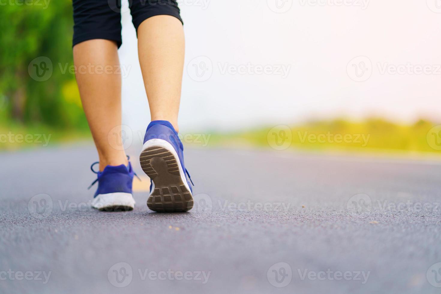 Pies de mujer corriendo en la carretera, entrenamiento de mujer de fitness saludable foto