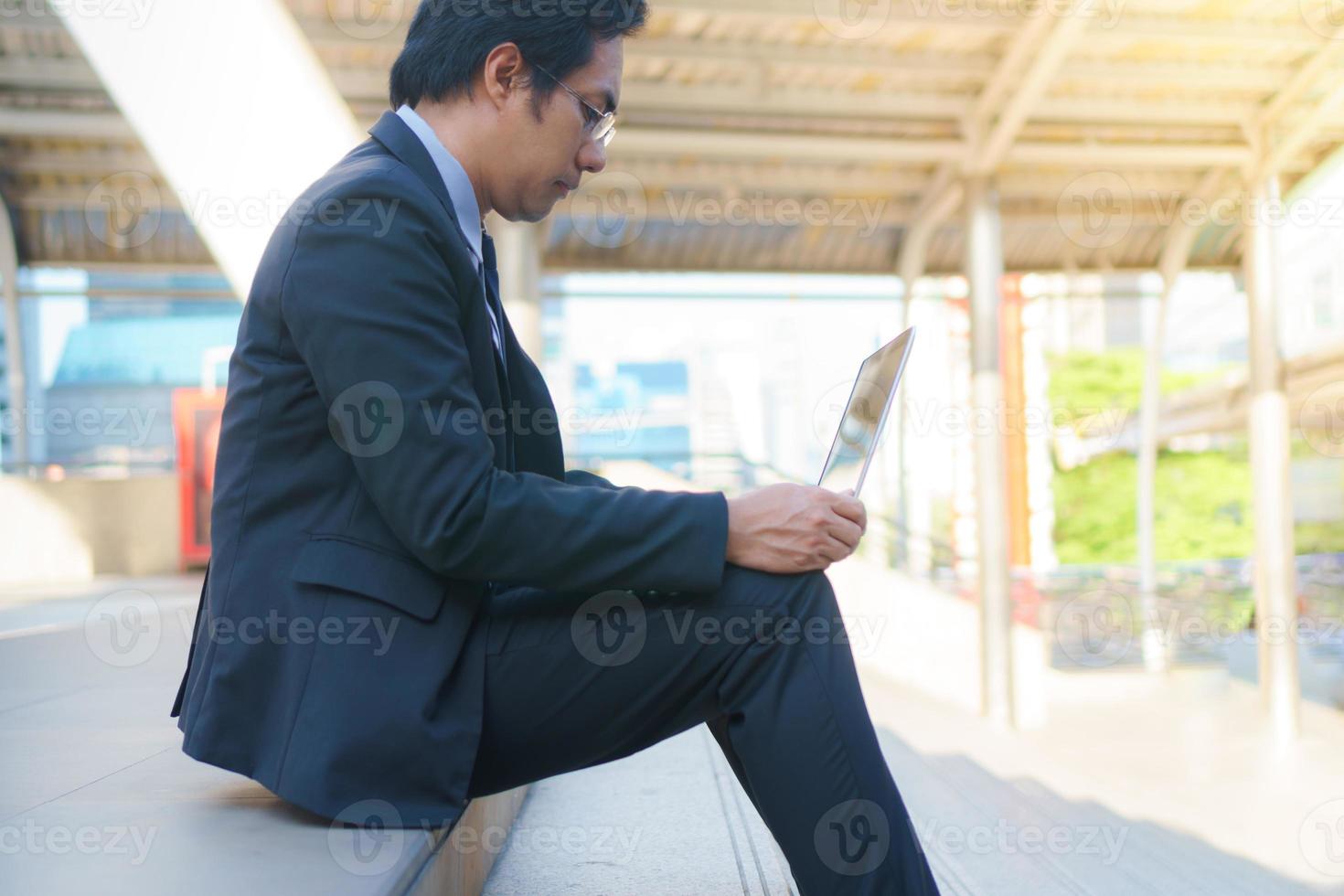 Businessman sitting on the footsteps with laptop photo