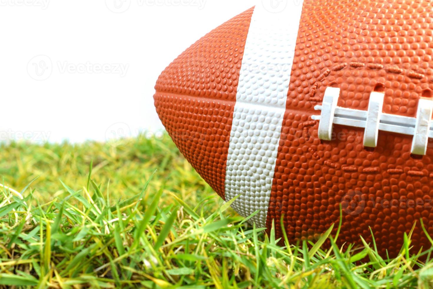 American Football ball on green grass isolated on white background photo