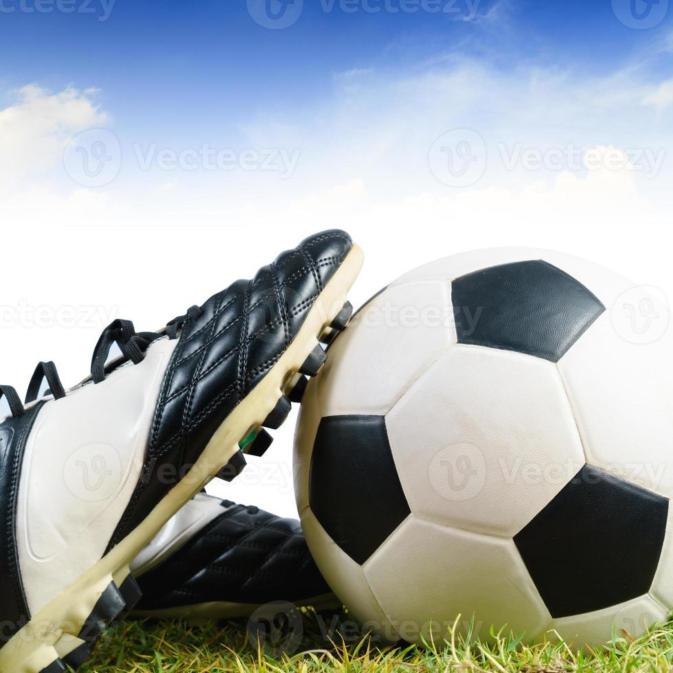 Soccer ball and shoes on grass photo