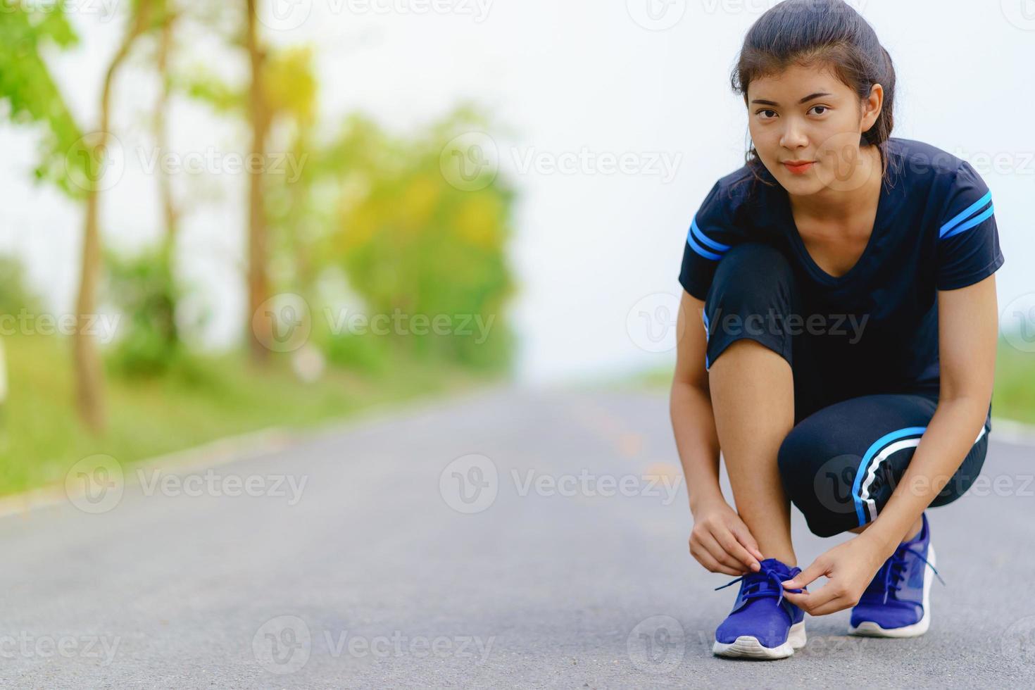 corredor de la muchacha tratando de zapatos para correr preparándose para trotar foto