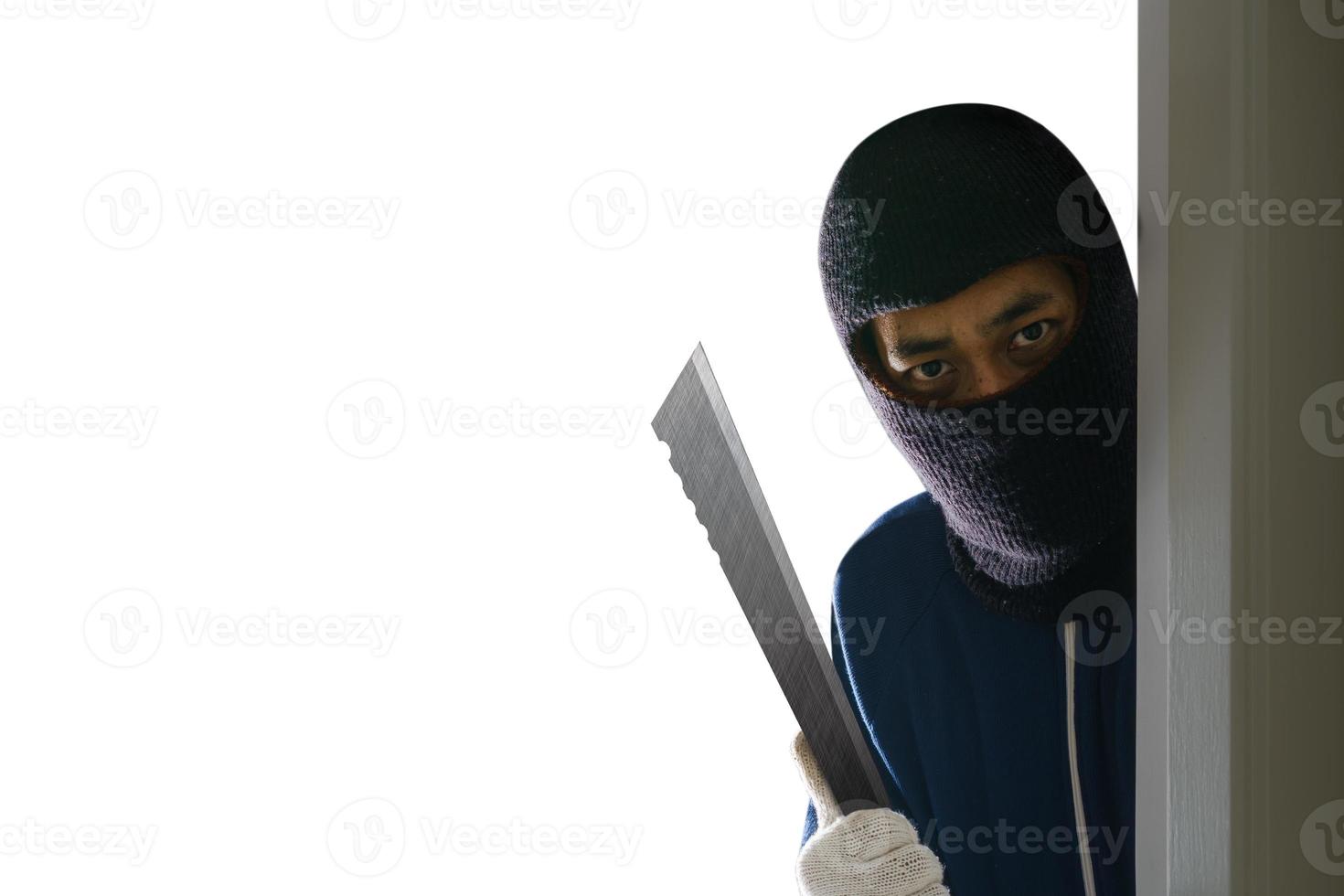 Masked robber with knife hiding behind the door photo