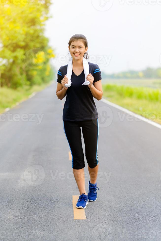 hermosa niña corriendo en la carretera, entrenamiento de mujer fitness saludable foto