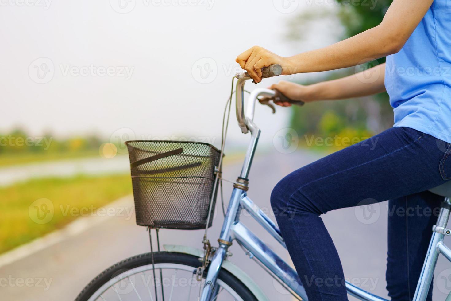 niña con bicicleta, mujer en bicicleta en la carretera en un parque foto