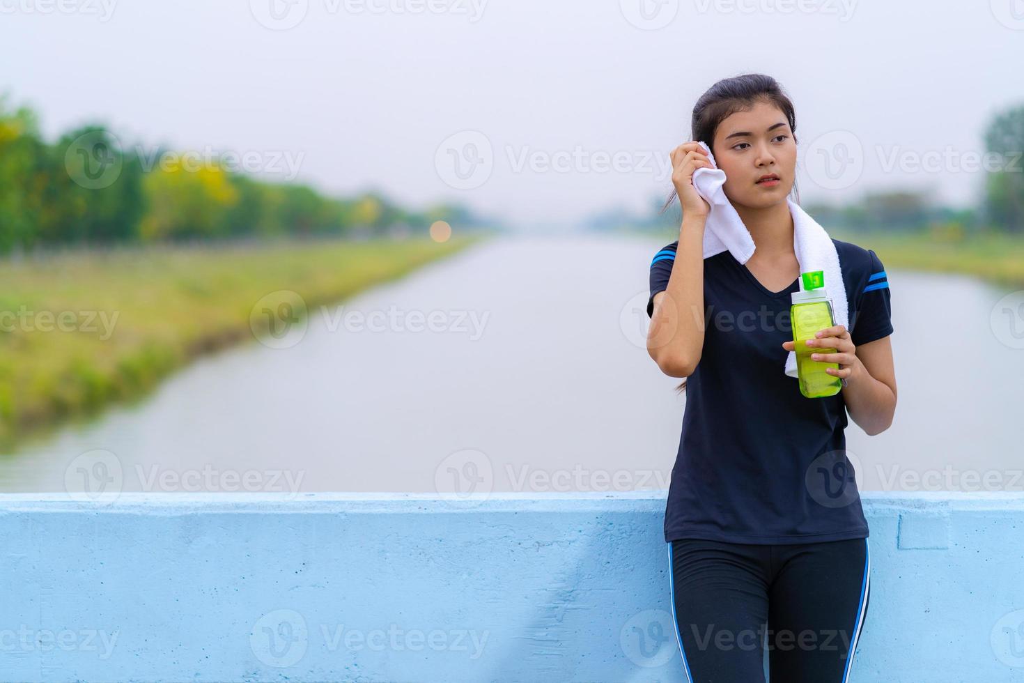 Retrato de una hermosa niña en ropa deportiva con una botella de agua foto