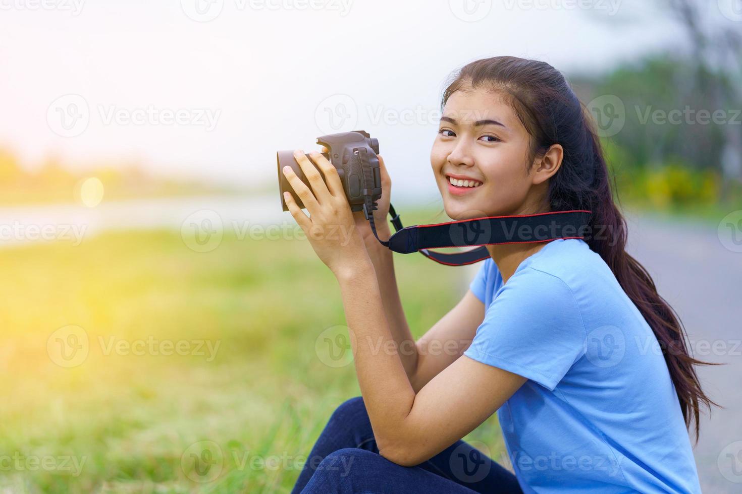 Retrato de una hermosa niña sonriendo con una cámara en las manos foto