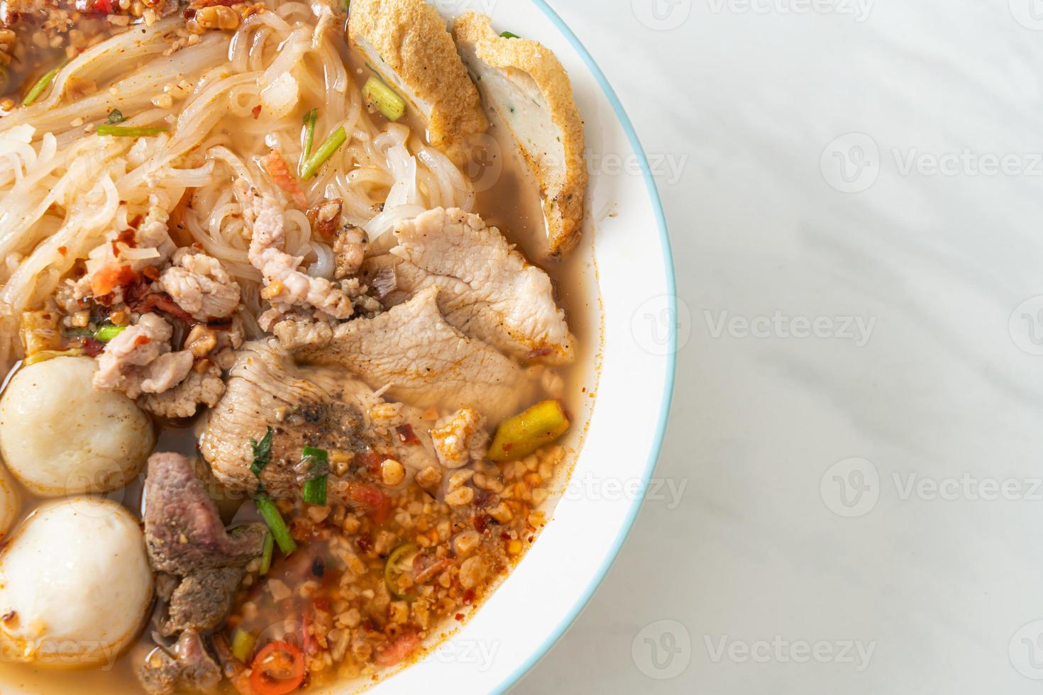 Noodles with pork and meatballs in spicy soup or Tom yum noodles in Asian style photo