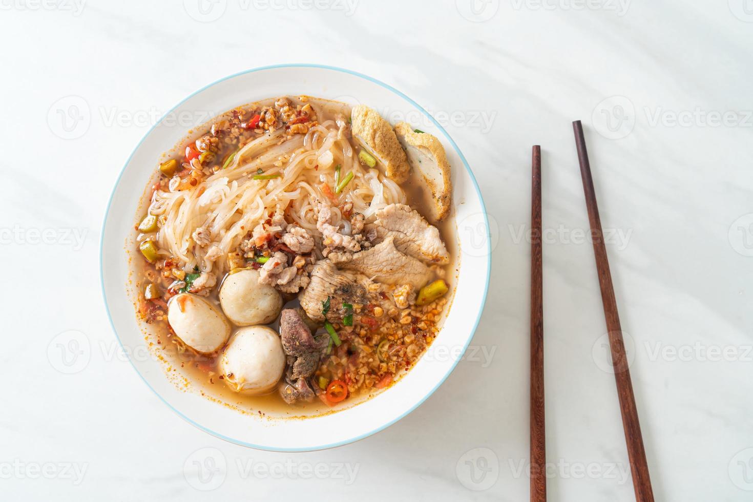 fideos con carne de cerdo y albóndigas en sopa picante o fideos tom yum al estilo asiático foto