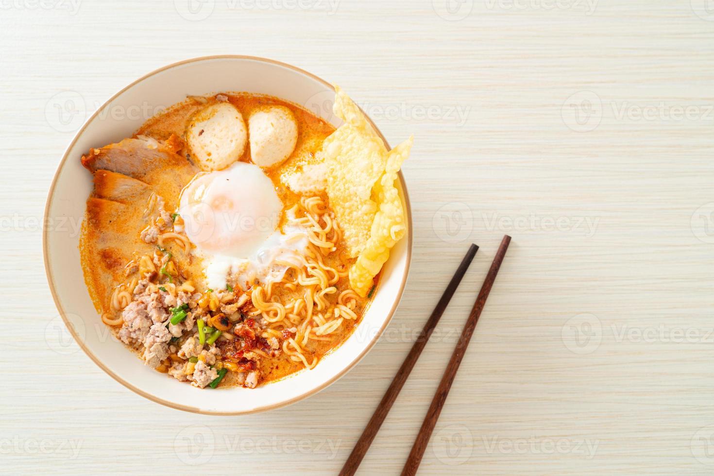 fideos instantáneos con carne de cerdo y albóndigas en sopa picante o fideos tom yum al estilo asiático foto