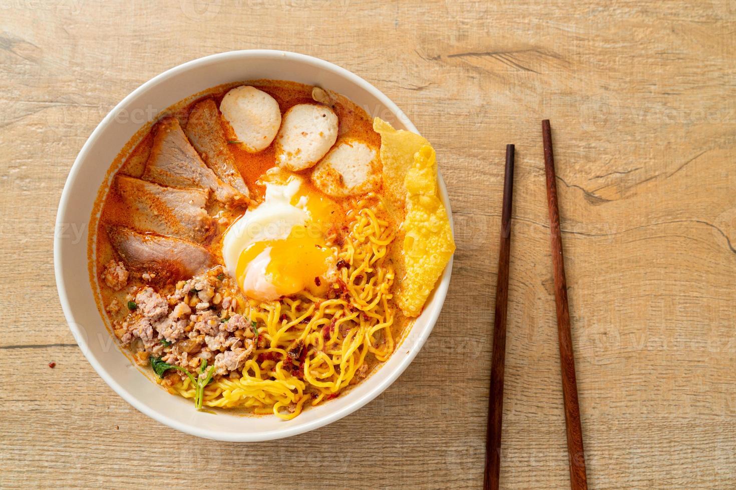 Egg noodles with pork and meatball in spicy soup or Tom Yum Noodles in Asian style photo