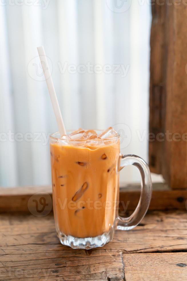 Vaso de té con leche tailandés helado en café restaurante foto