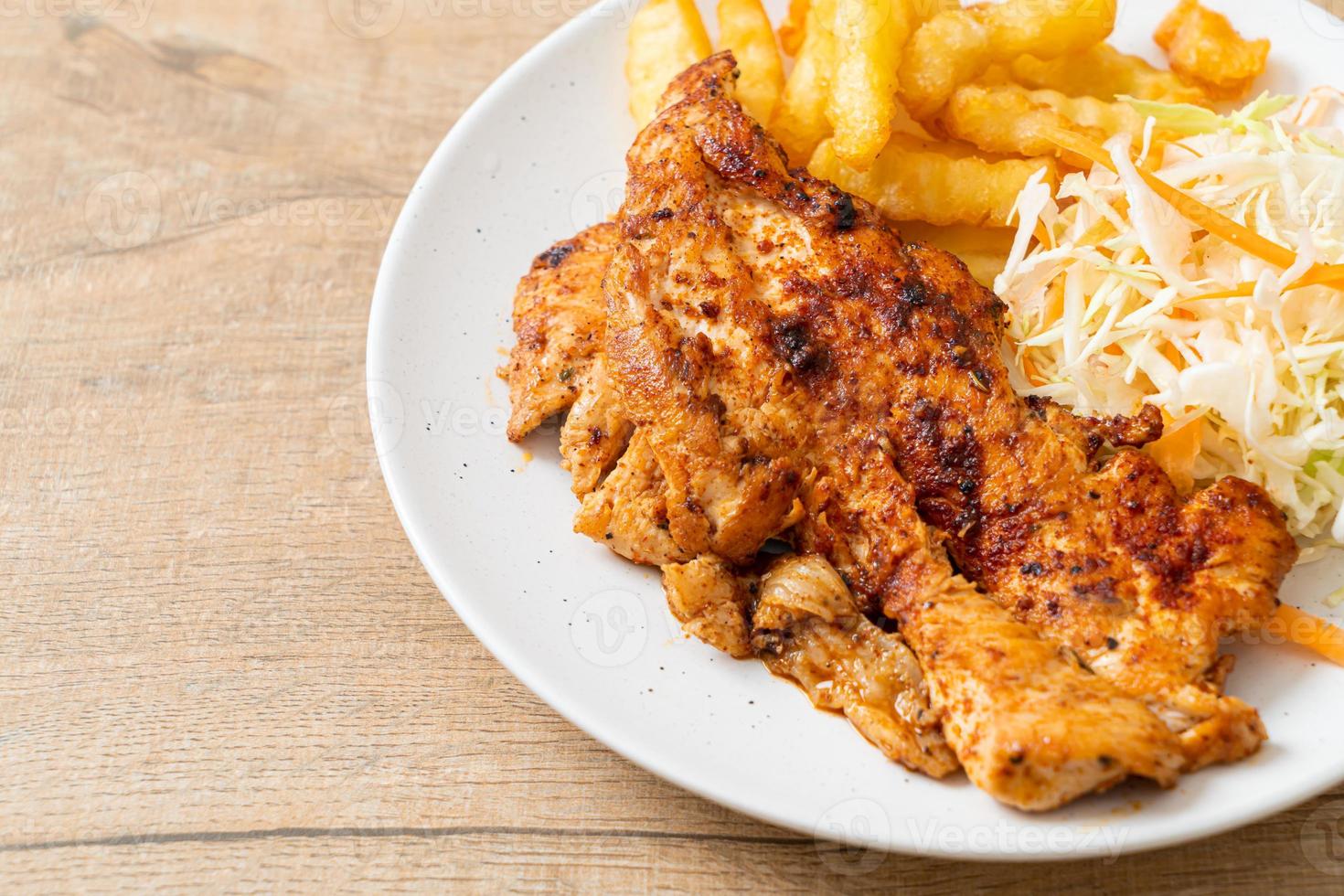 Filete de pollo asado picante a la parrilla con papas fritas foto