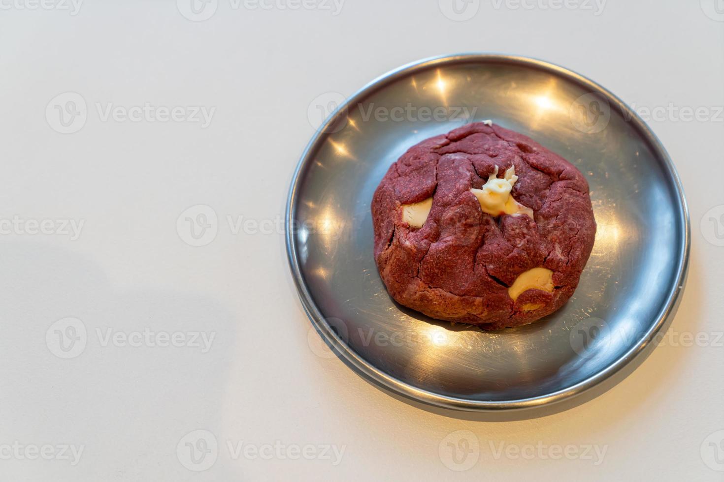 Galleta de terciopelo rojo con nuez de macadamia en placa foto