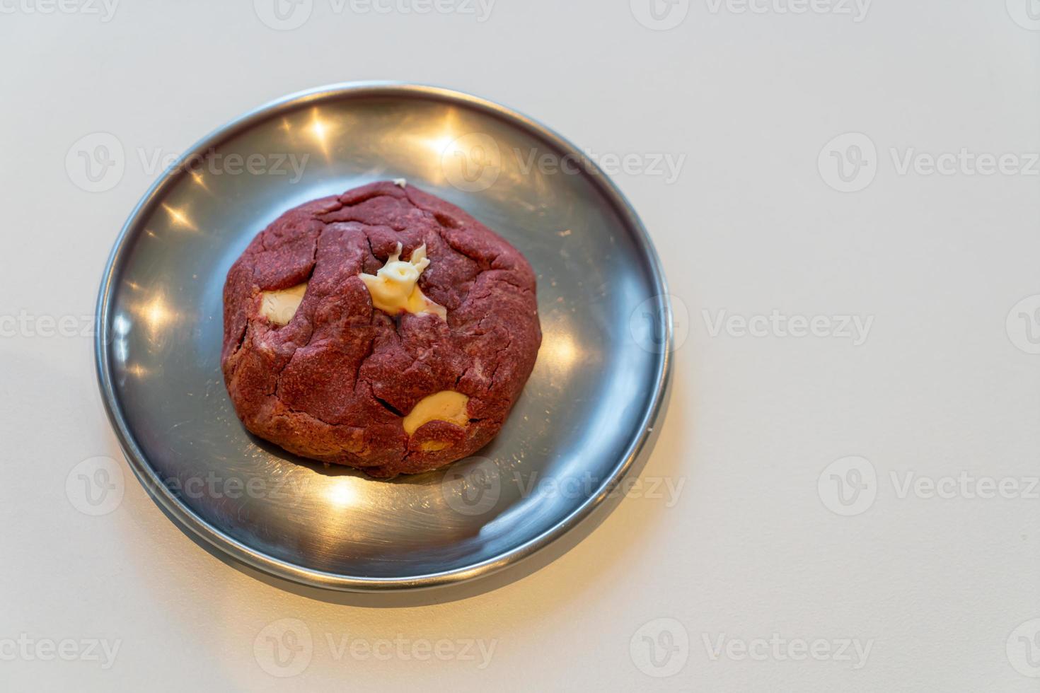 Galleta de terciopelo rojo con nuez de macadamia en placa foto