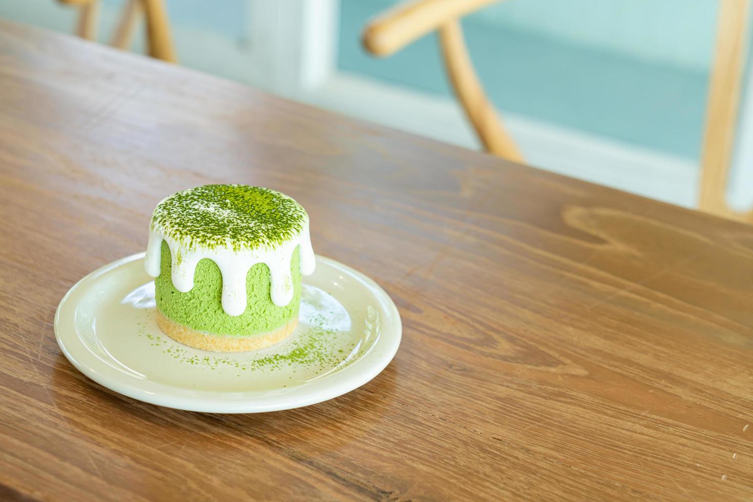 Tarta de queso con té verde matcha en la mesa en el restaurante cafetería foto