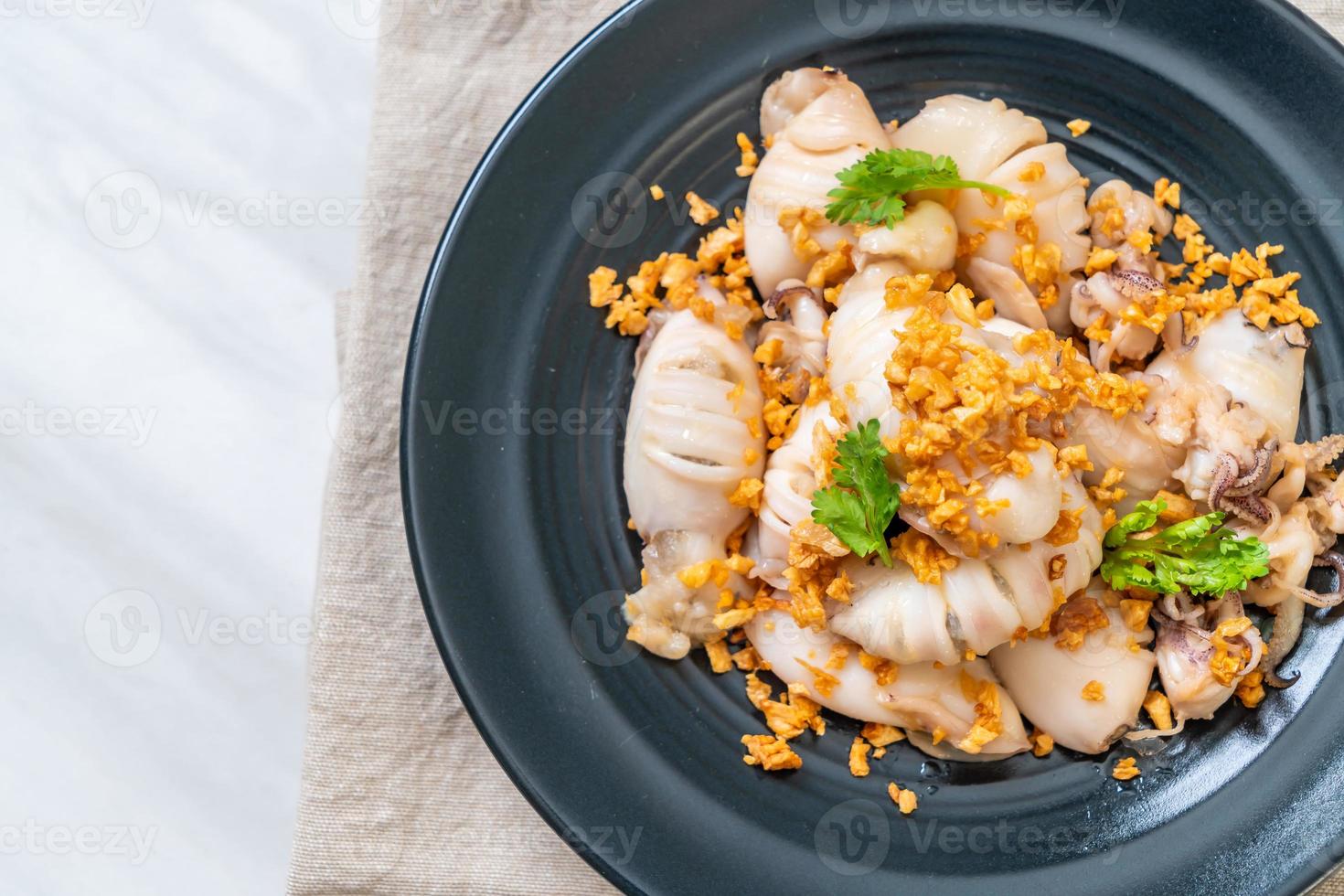 Fried squid or octopus with garlic on plate photo