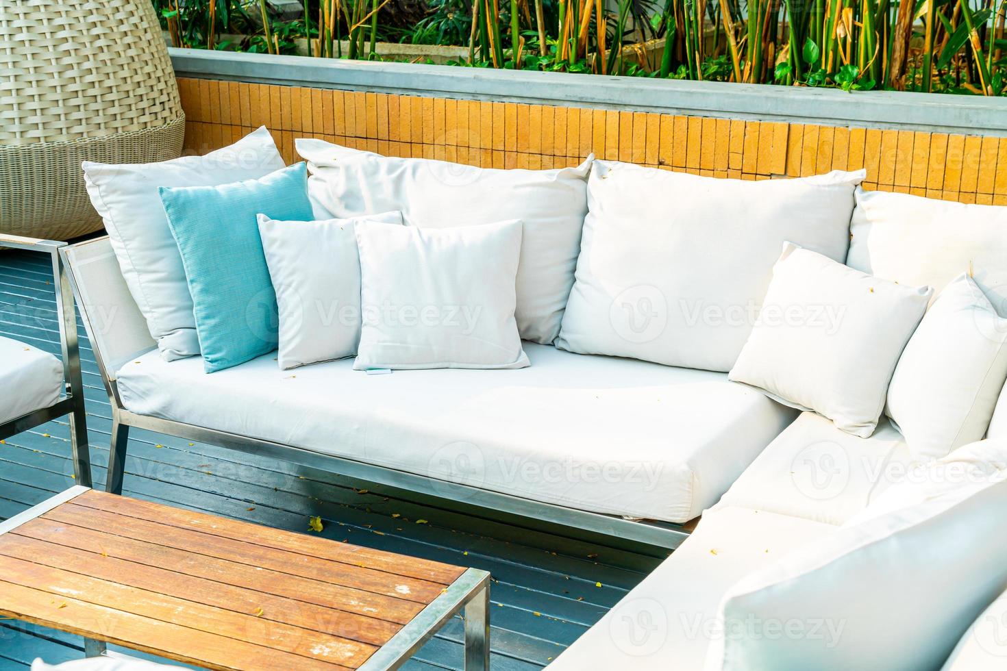 Cómodas almohadas en una mesa y una silla de patio al aire libre en el jardín foto