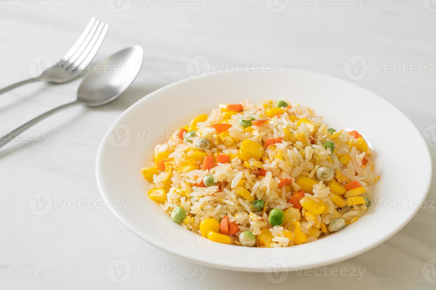 Homemade fried rice with mixed vegetables of carrot, green bean peas, corn, and egg photo