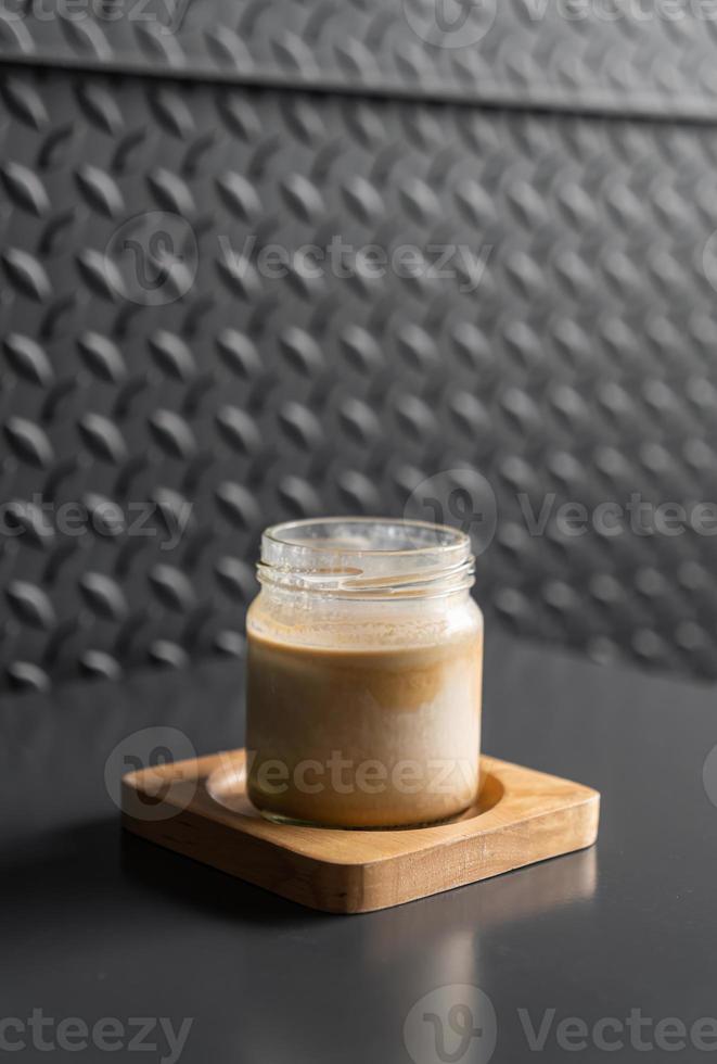 A glass of espresso shot over cold fresh milk create gradient layer called dirty coffee photo