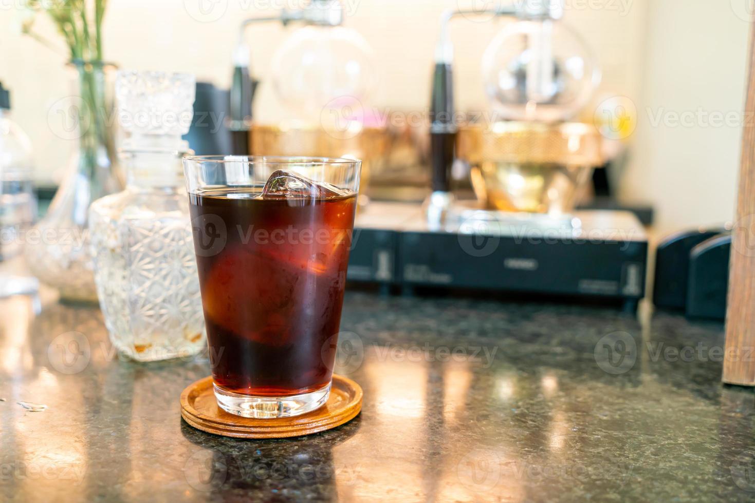 Café frío o café americano negro en vaso con cubitos de hielo en la cafetería, cafetería y restaurante foto