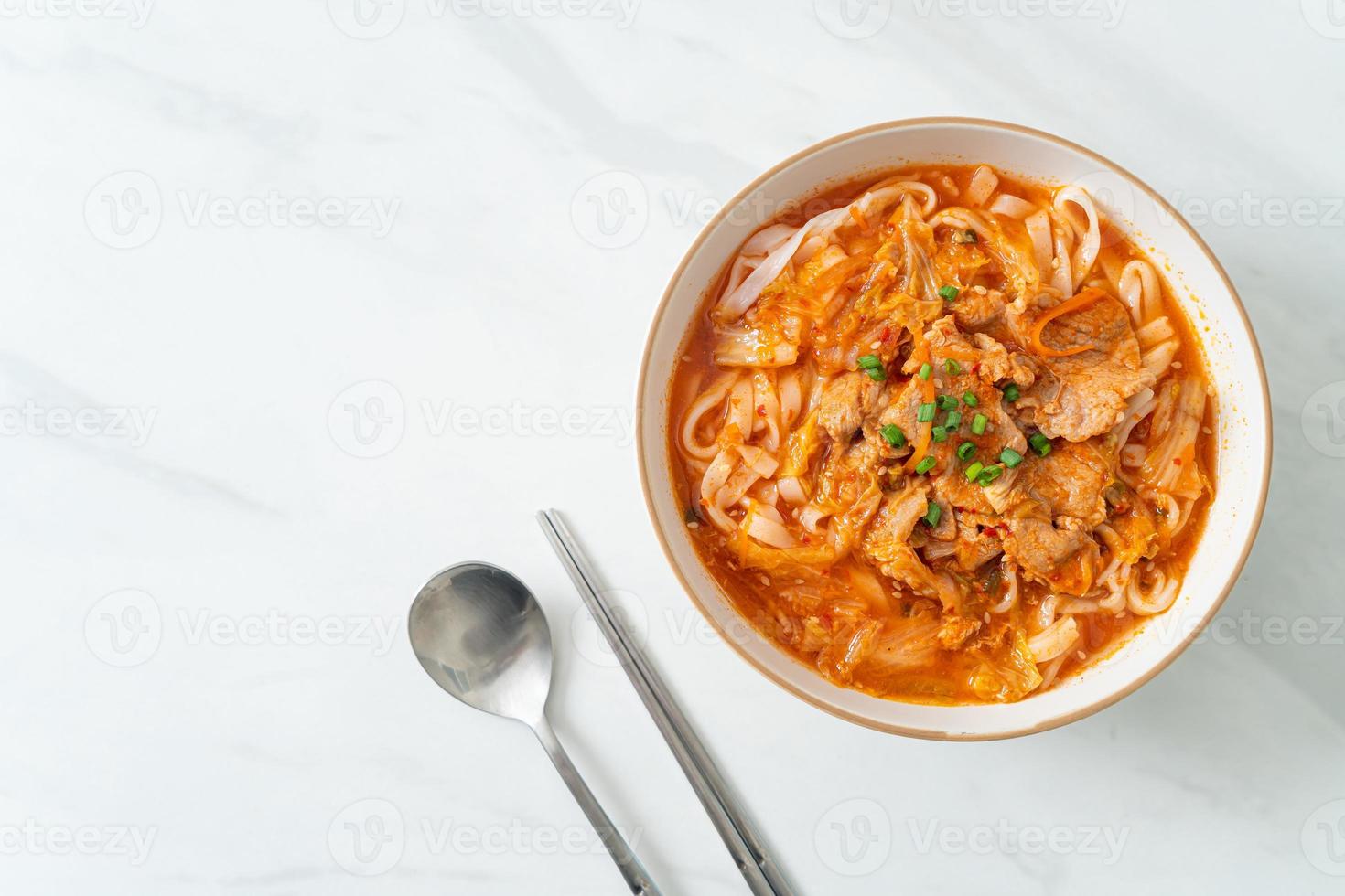 Korean udon ramen noodles with pork in kimchi soup photo