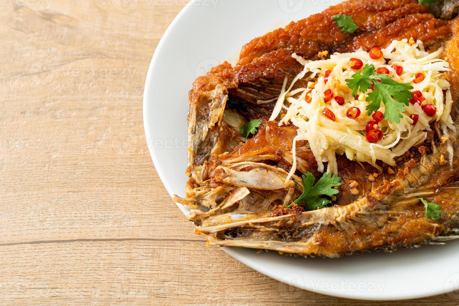 Lubina frita con salsa de pescado y ensalada picante foto