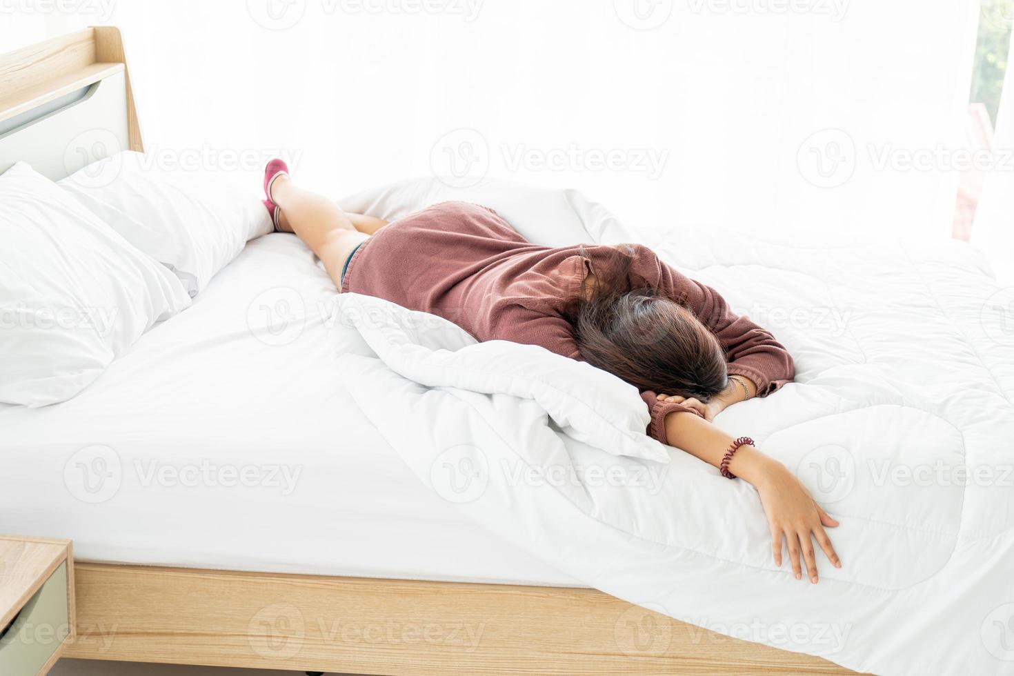 Hermosa mujer asiática durmiendo en la cama por la mañana foto