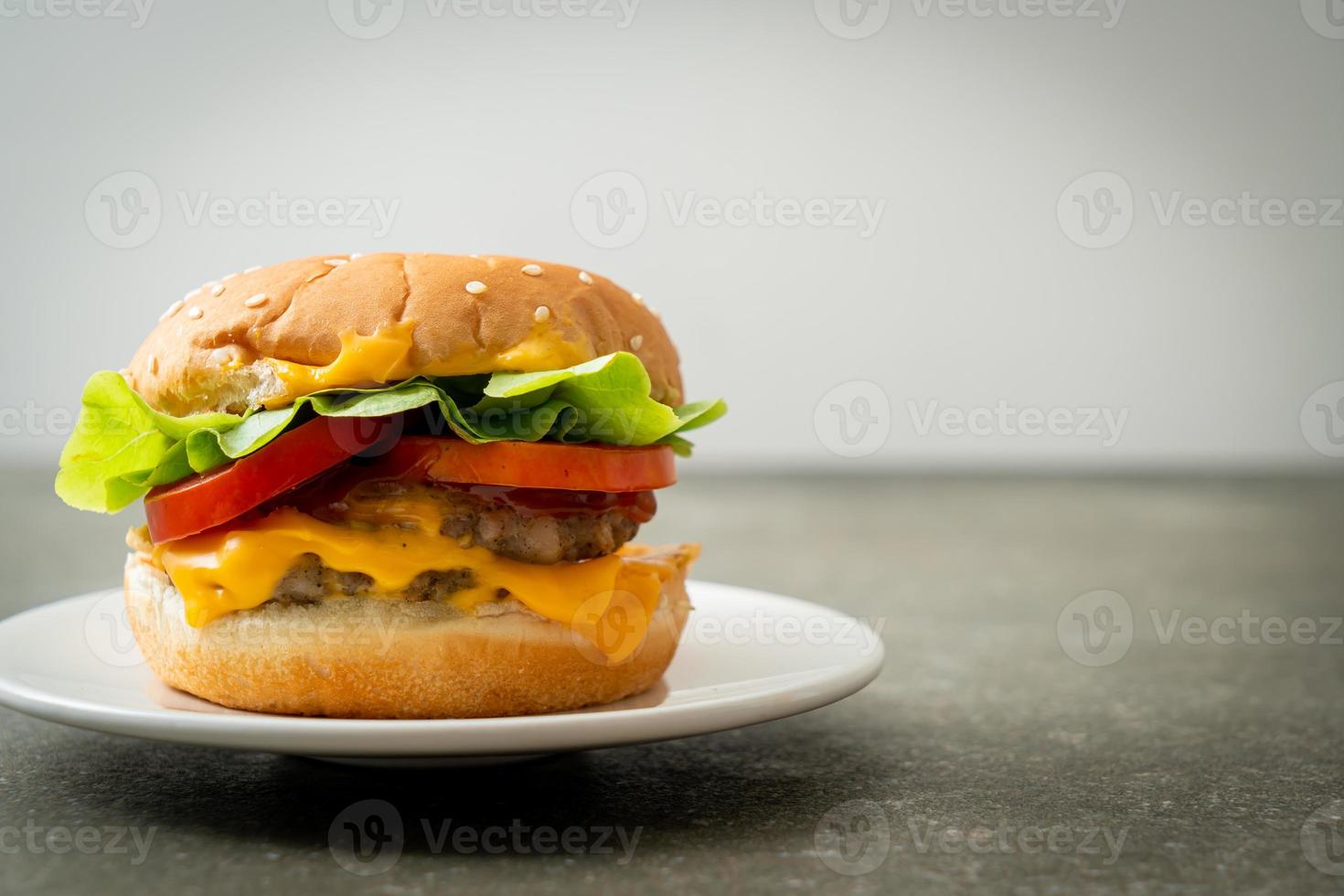 Hamburguesa de cerdo con queso en la placa blanca. foto