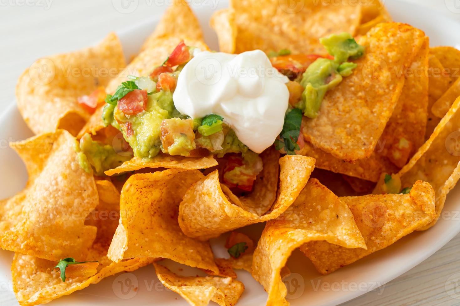 nachos mexicanos tortilla chips con jalapeño, guacamole, salsa de tomate y dip foto