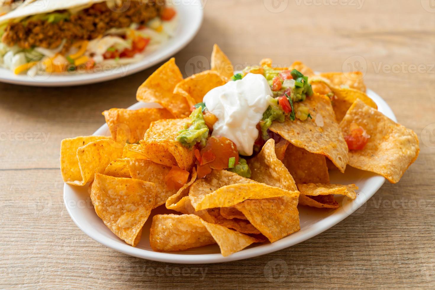 nachos mexicanos tortilla chips con jalapeño, guacamole, salsa de tomate y dip foto