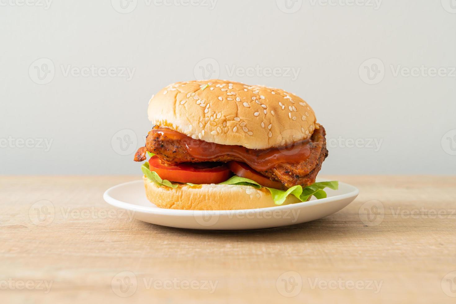 Hamburguesa de pollo a la parrilla con salsa en la placa blanca. foto