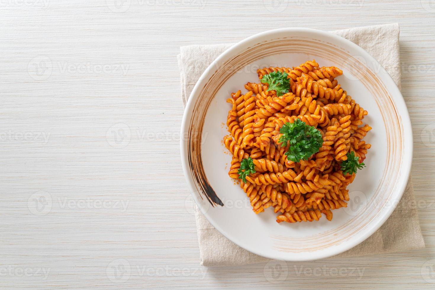 pasta en espiral o spirali con salsa de tomate y salchicha - estilo de comida italiana foto