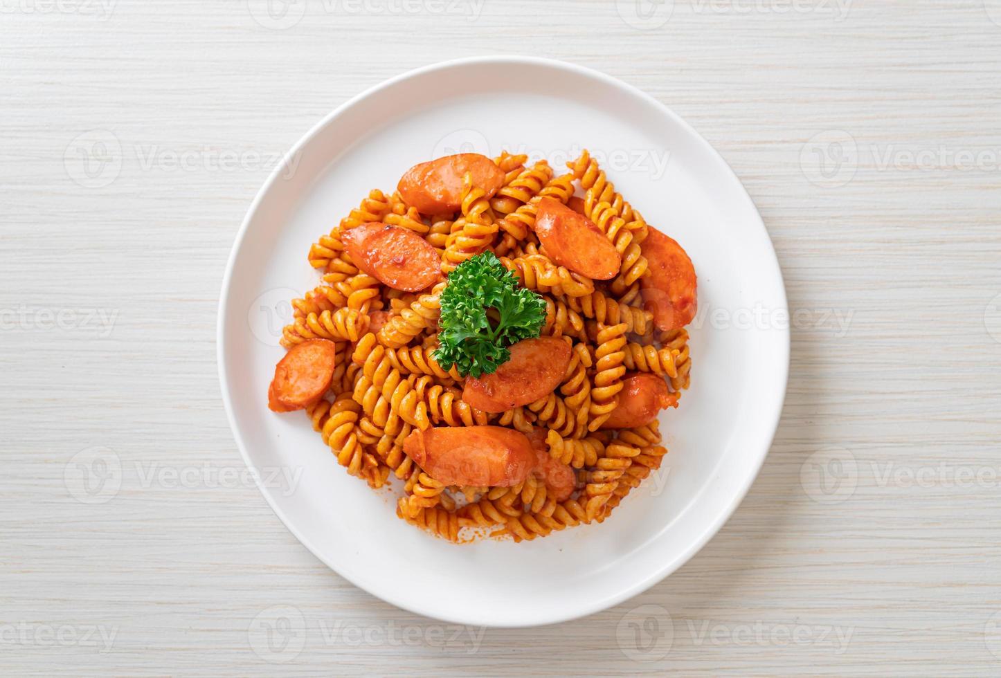 pasta en espiral o spirali con salsa de tomate y salchicha - estilo de comida italiana foto