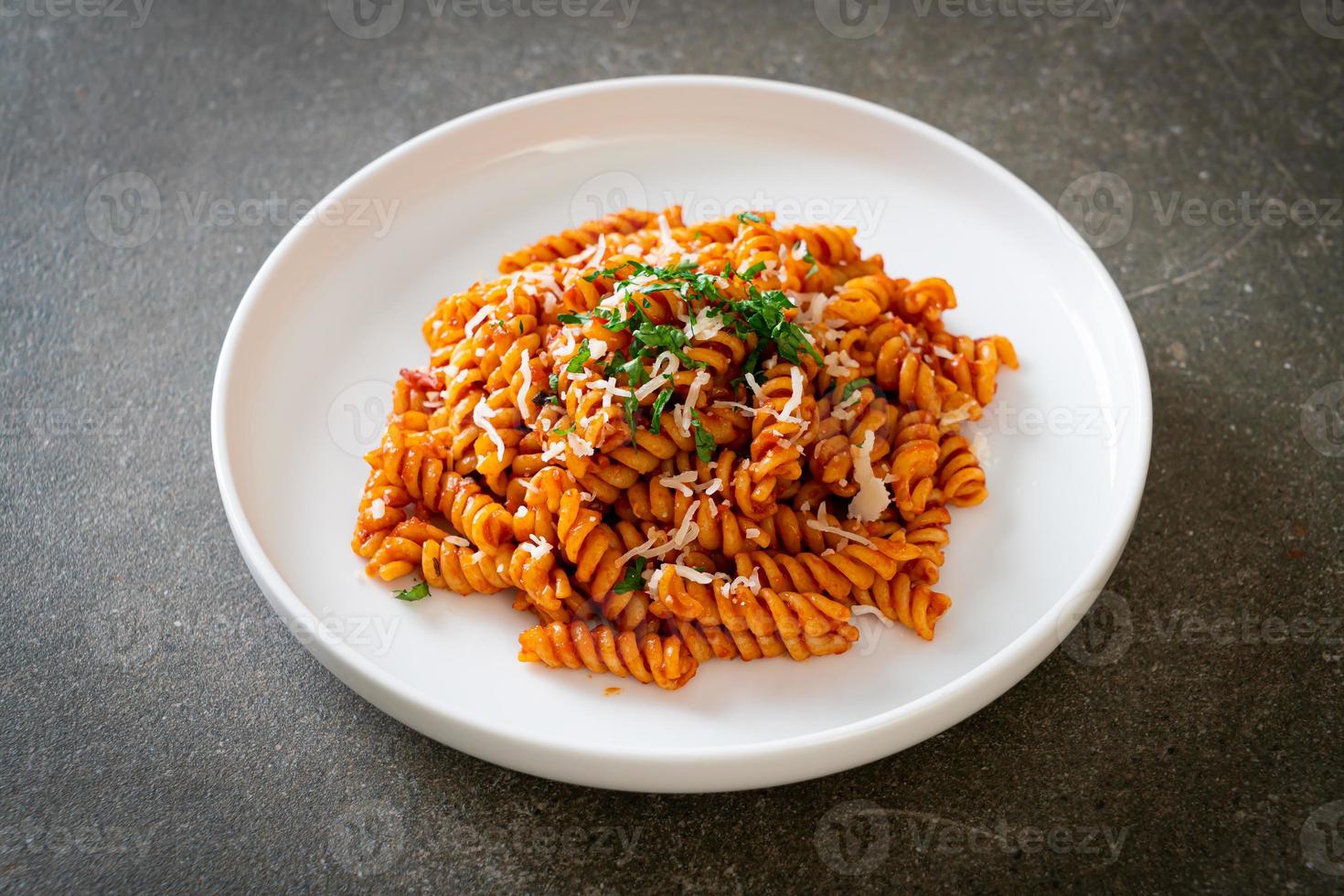 pasta en espiral o spirali con salsa de tomate y salchicha - estilo de comida italiana foto