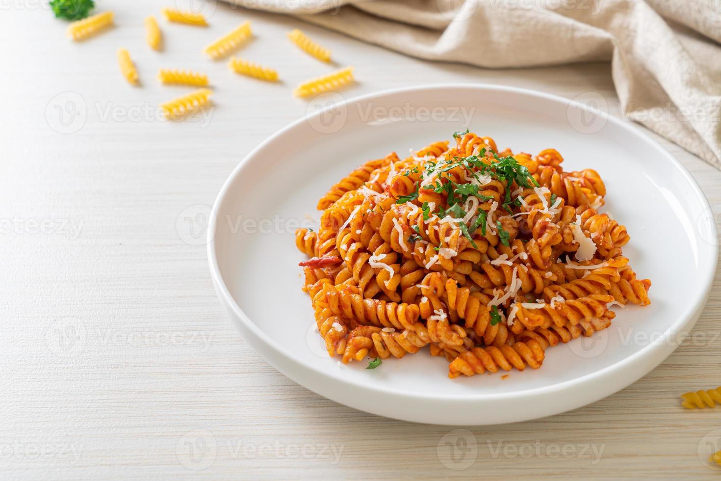 pasta en espiral o spirali con salsa de tomate y salchicha - estilo de comida italiana foto