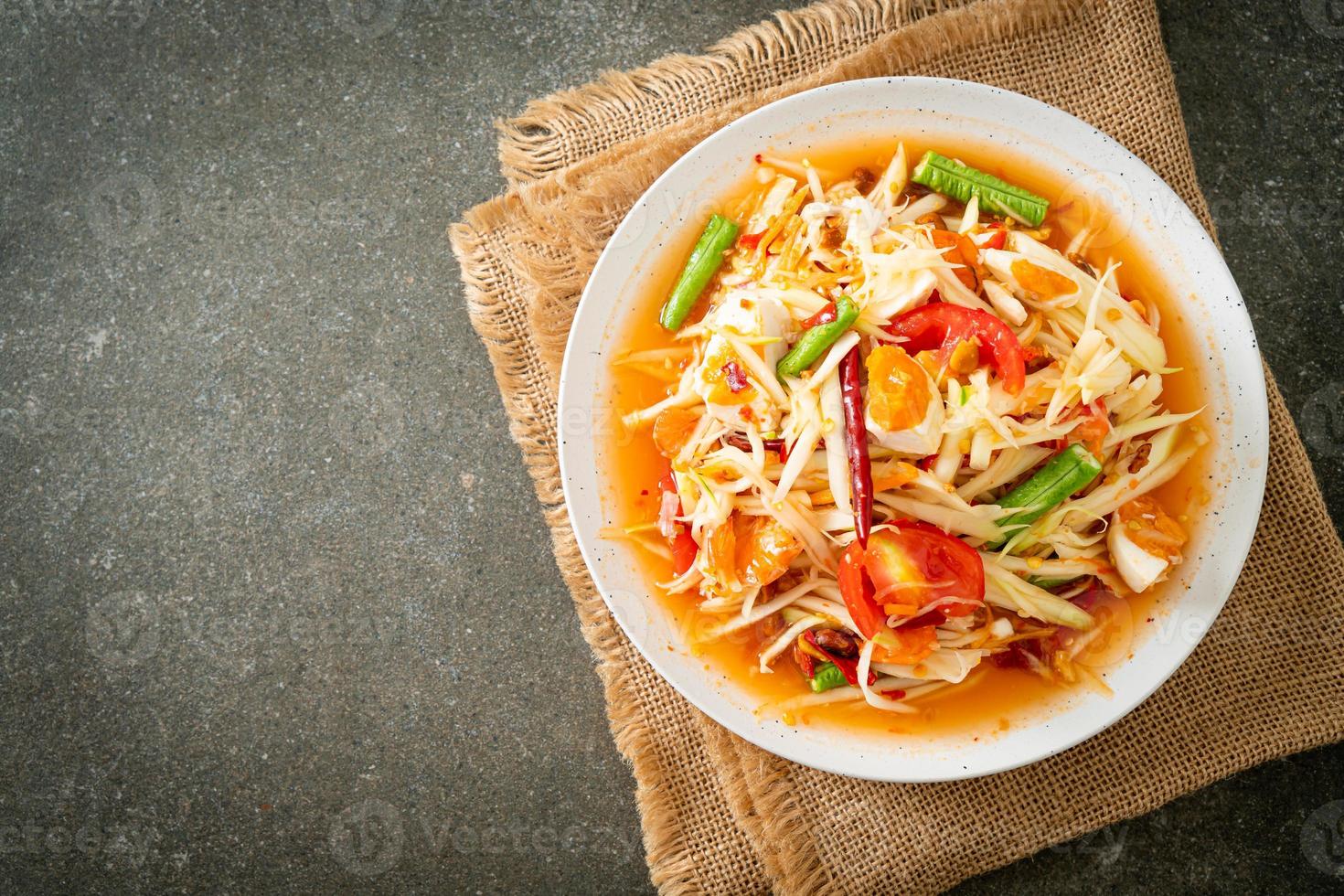 som tum - ensalada tailandesa de papaya verde picante con huevos salados foto