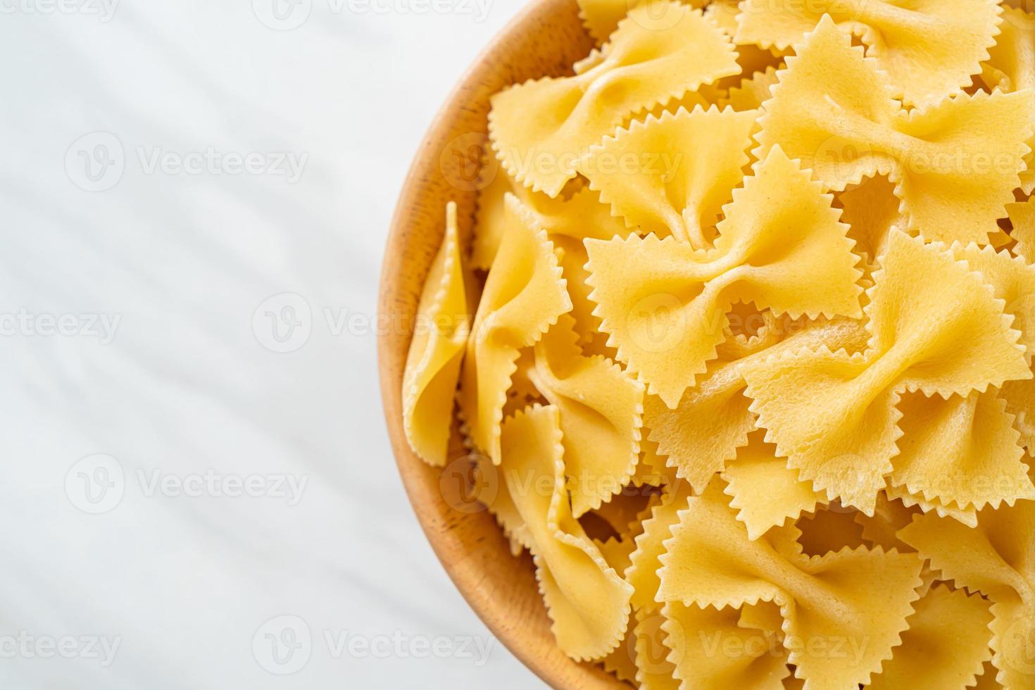 Dry uncooked farfalle pasta in bowl photo