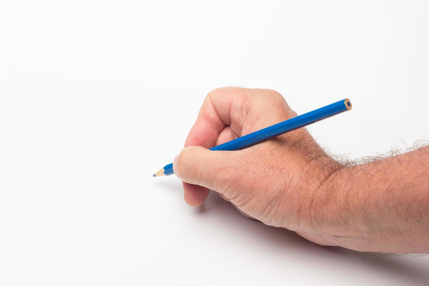 Coloured pencil in hand on white background photo