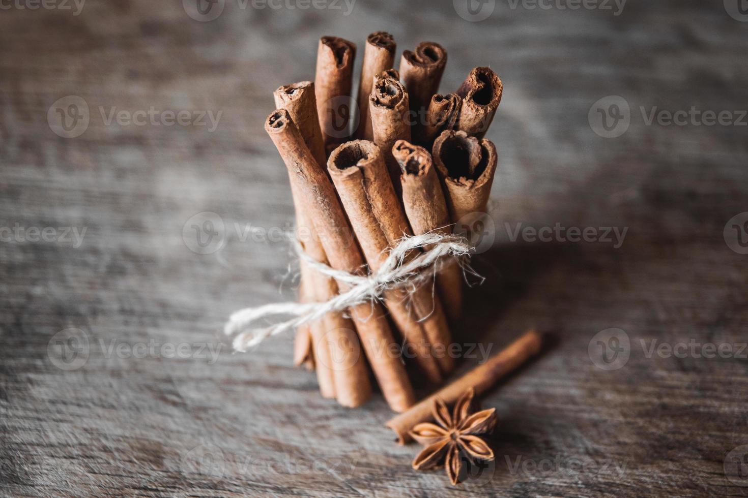 Cinnamon sticks and aniseon on the wooden surface photo